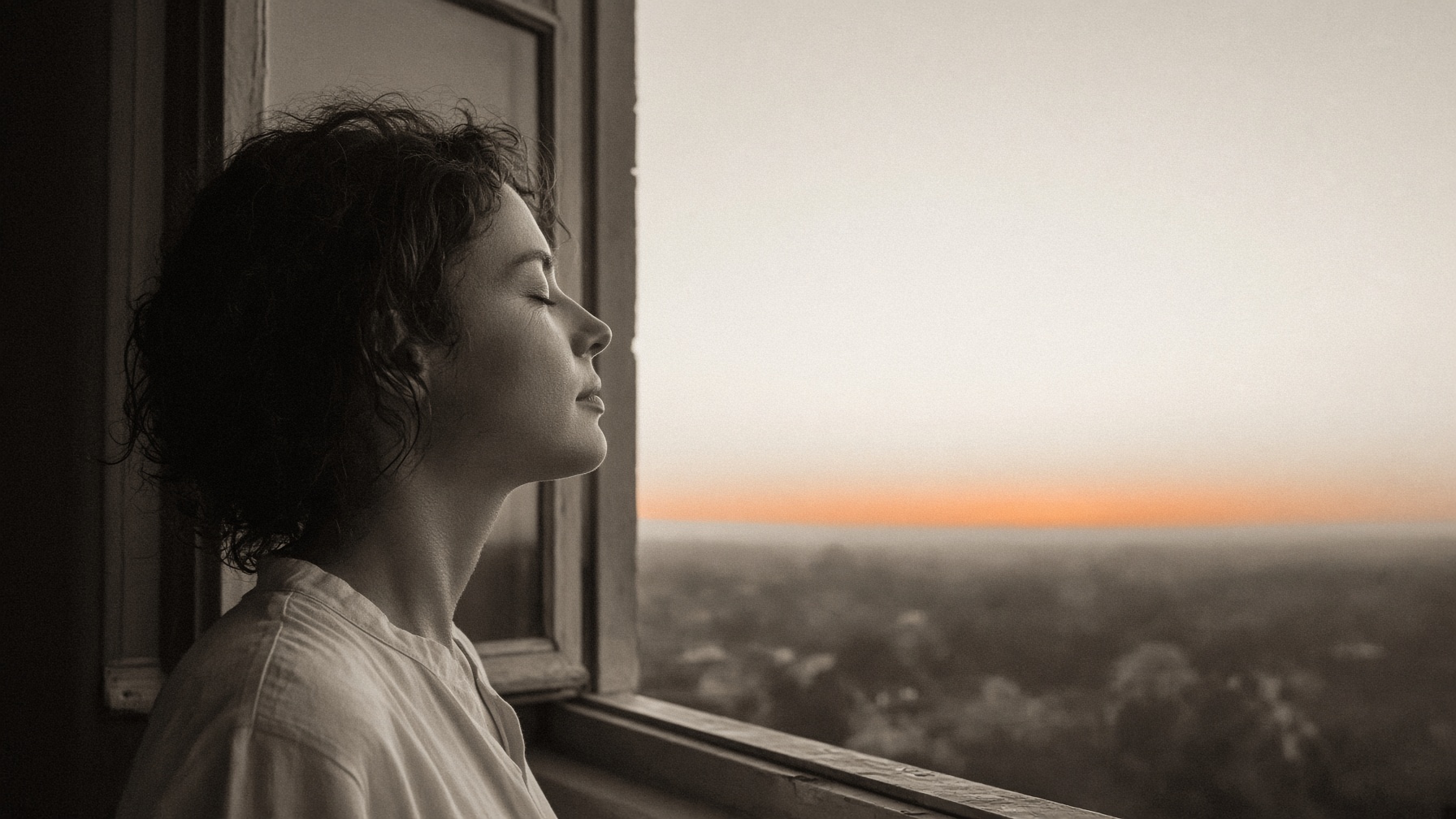 A person breathing slowly through the nose at an open window at dawn.